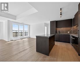 A modern kitchen with dark wood cabinets and a large island.