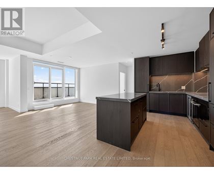 A modern kitchen with dark wood cabinets and a large island.