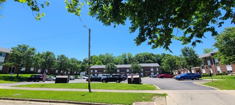 A street view of a residential area with houses and parked cars.