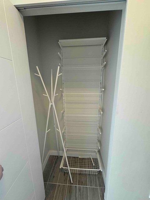 A white refrigerator with a wire shelf and a white door.