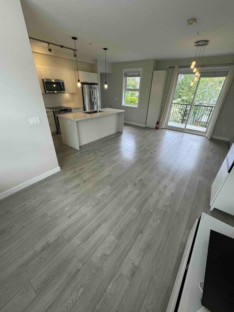 A spacious living room with a grey floor and white walls.