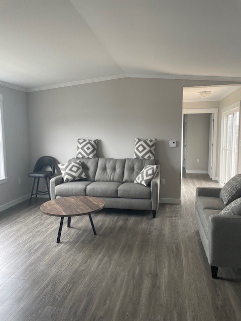 A grey couch with a wooden coffee table in front of it.