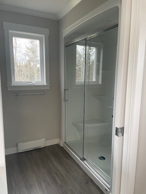 A bathroom with a glass shower door and a window.