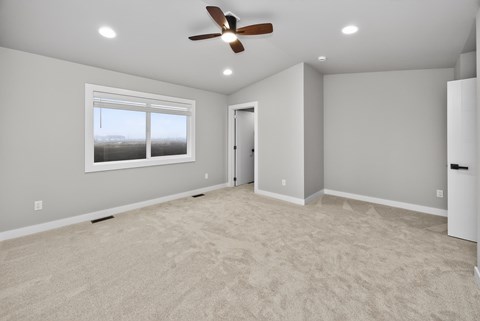 A room with a ceiling fan and a window.