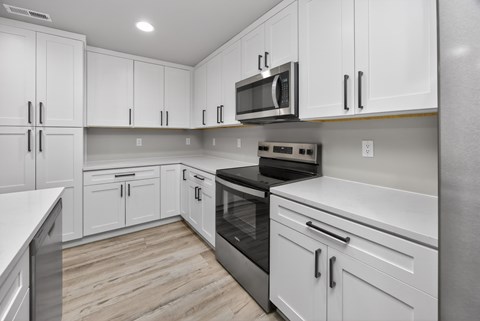 A kitchen with white cabinets and stainless steel appliances.