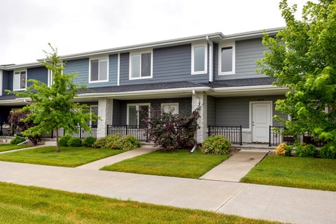 A grey house with a white door and windows.
