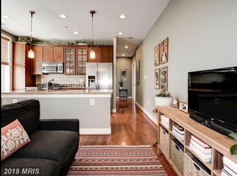 A living room with a black couch and a television.