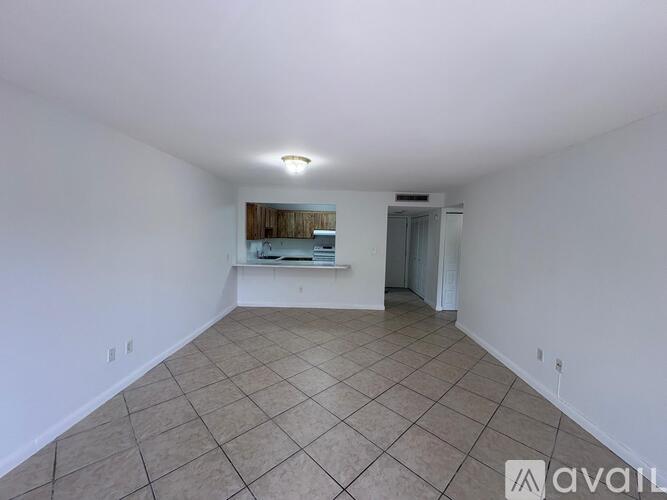 A spacious room with tiled flooring and white walls.