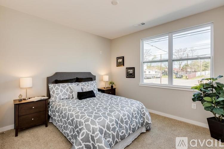 A bedroom with a large bed and two lamps.