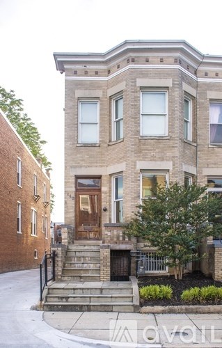 A brown brick house with a black metal railing.