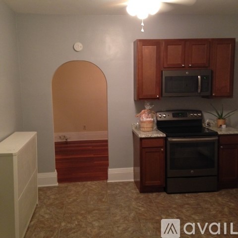 A kitchen with brown cabinets and a black stove top oven.