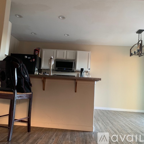 A kitchen with a wooden floor and a white ceiling.