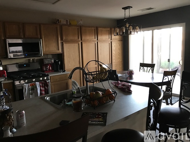 A kitchen with a table and chairs in front of a window.