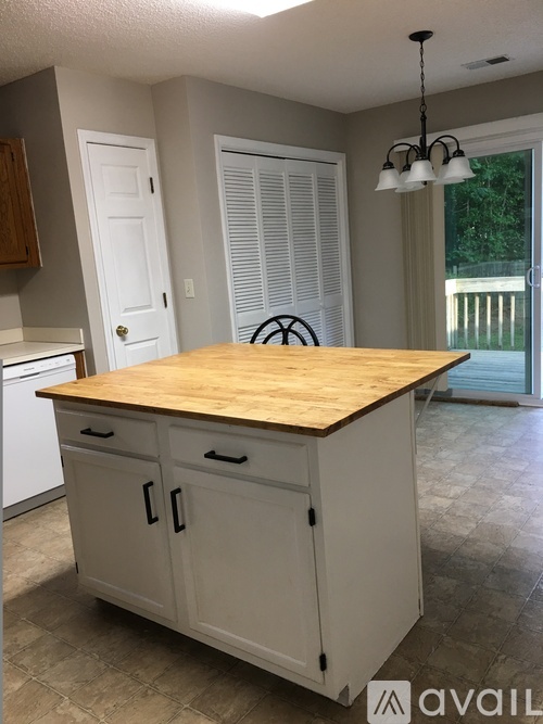 A kitchen island with a wooden top and white cabinets.