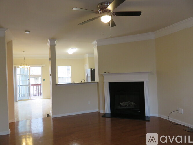 A living room with a fireplace and a ceiling fan.