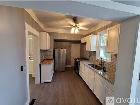 A kitchen with white cabinets and a stainless steel refrigerator.