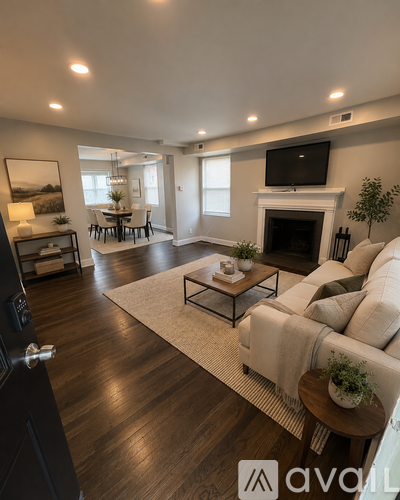 A living room with a white couch and a fireplace.