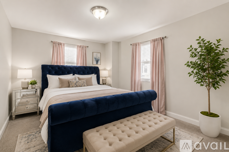 A bedroom with a large bed and a potted plant.