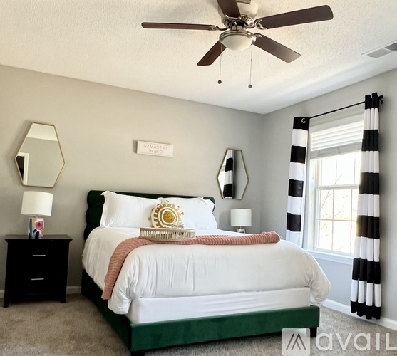 A bedroom with a large bed and a ceiling fan.
