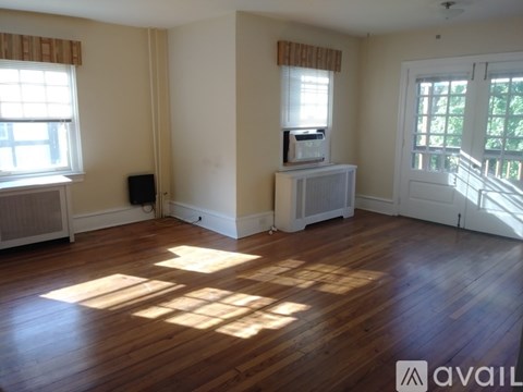 A room with wooden floors and a window with blinds.