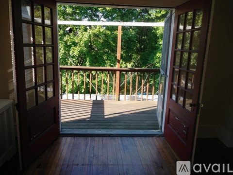 A balcony with a view of trees and a deck.