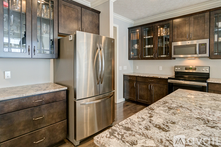 A kitchen with a granite counter top and stainless steel appliances.