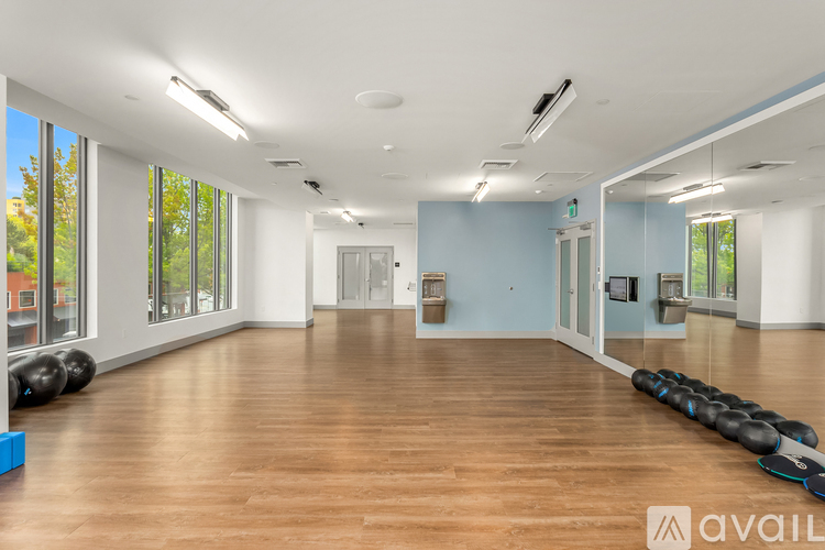 A gym with wooden floors and exercise equipment.