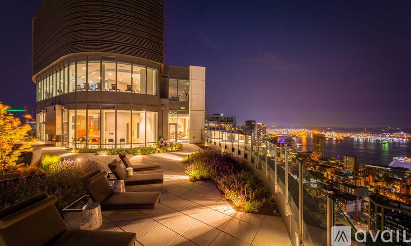 A modern building with a curved design is illuminated at night.
