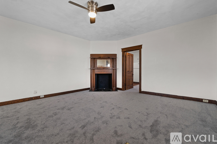A room with a fireplace and a ceiling fan.