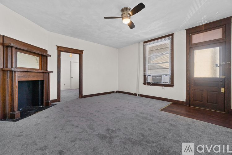 A room with a fireplace and a ceiling fan.