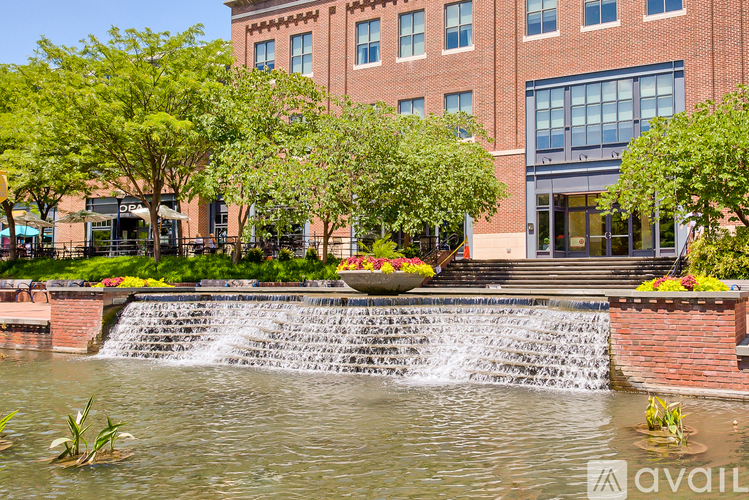 A waterfall in a pond in front of a building.