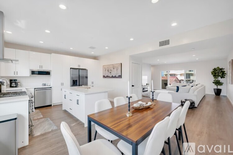A modern kitchen with a dining table and chairs.