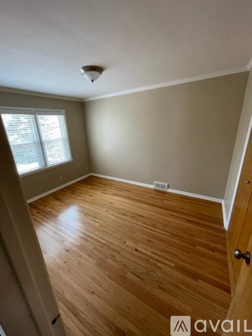 A room with wooden flooring and a window.