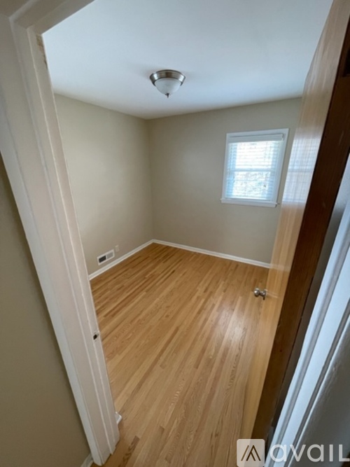 A room with wooden flooring and a window.
