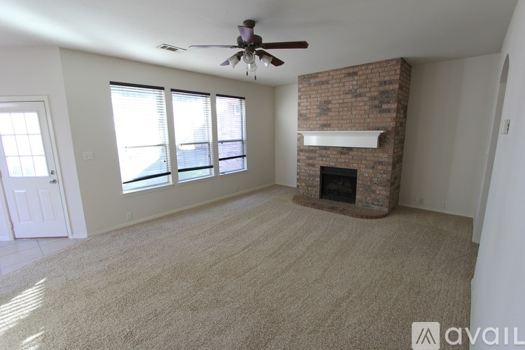 A living room with a fireplace and a ceiling fan.