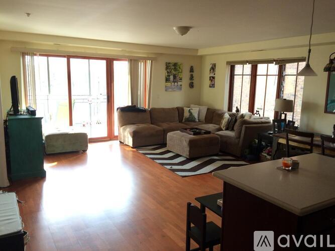A living room with a brown couch and a wooden floor.