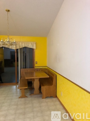 A dining room with a wooden table and chairs.