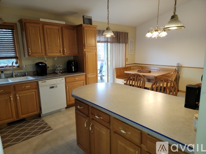 A kitchen with wooden cabinets and a dining table with chairs.