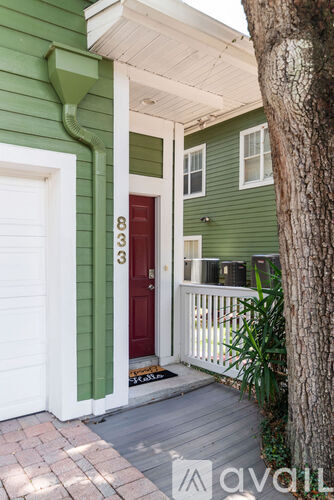 A green house with a red door numbered 83.