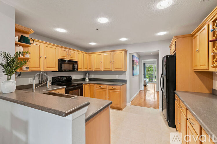 A kitchen with wooden cabinets and a black refrigerator.
