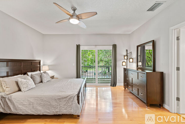 A bedroom with a large bed and a ceiling fan.