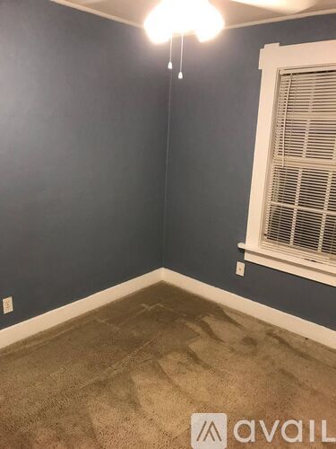 A room with a window and a carpet on the floor.