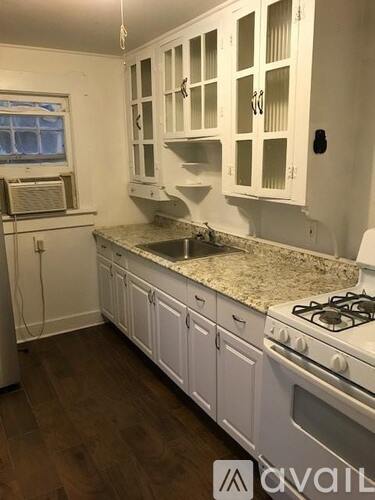 A kitchen with white cabinets and a granite countertop.