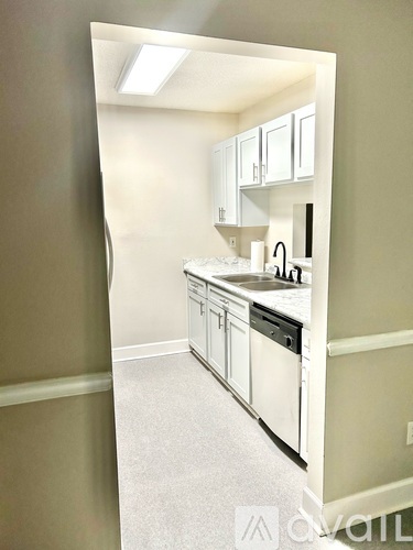 A kitchen with white cabinets and appliances.
