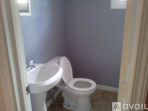 A white toilet and sink in a bathroom.
