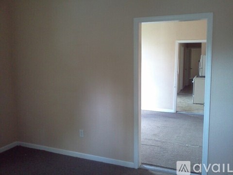 A room with a carpeted floor and a doorway leading to another room.
