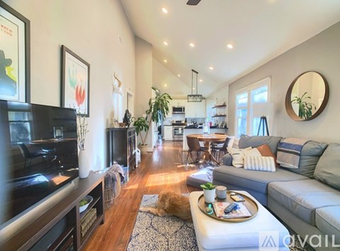 A living room with a grey couch and a coffee table in the middle.