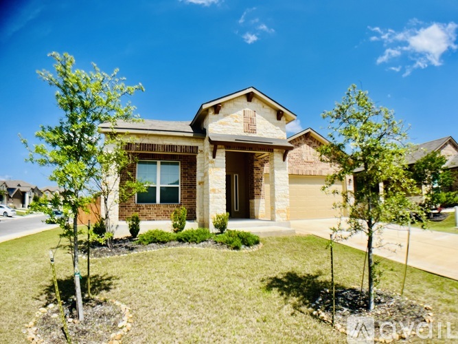 A house with a front yard and two trees.