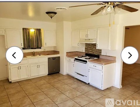 A kitchen with white cabinets and a tiled floor.