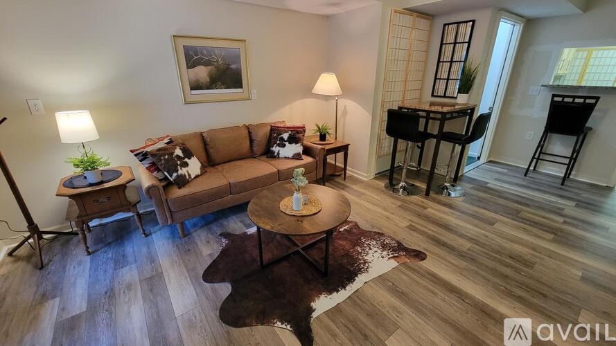 A living room with a brown couch, a coffee table, and a lamp.